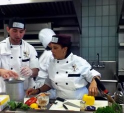 Photograph, by Claire Stewart, is of chefs Adrienne Jones and David Caban competing in the Kitchen Feud at the New York City College of Technology on April 25, 2013.