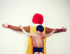 Ronald McDonald and Boy, arms spread, Christ-like